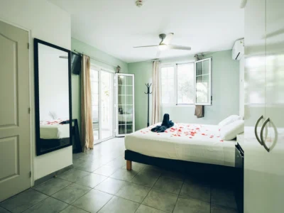 Chambre verte avec des serviettes en forme de signe avec des fleurs.