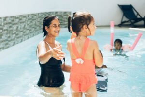 Une femme et une petite fille se baignent et s'amusent ensemble dans l'eau de la piscine.